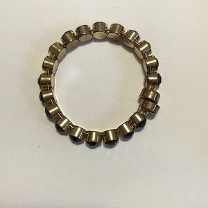 A gold bracelet with black gems